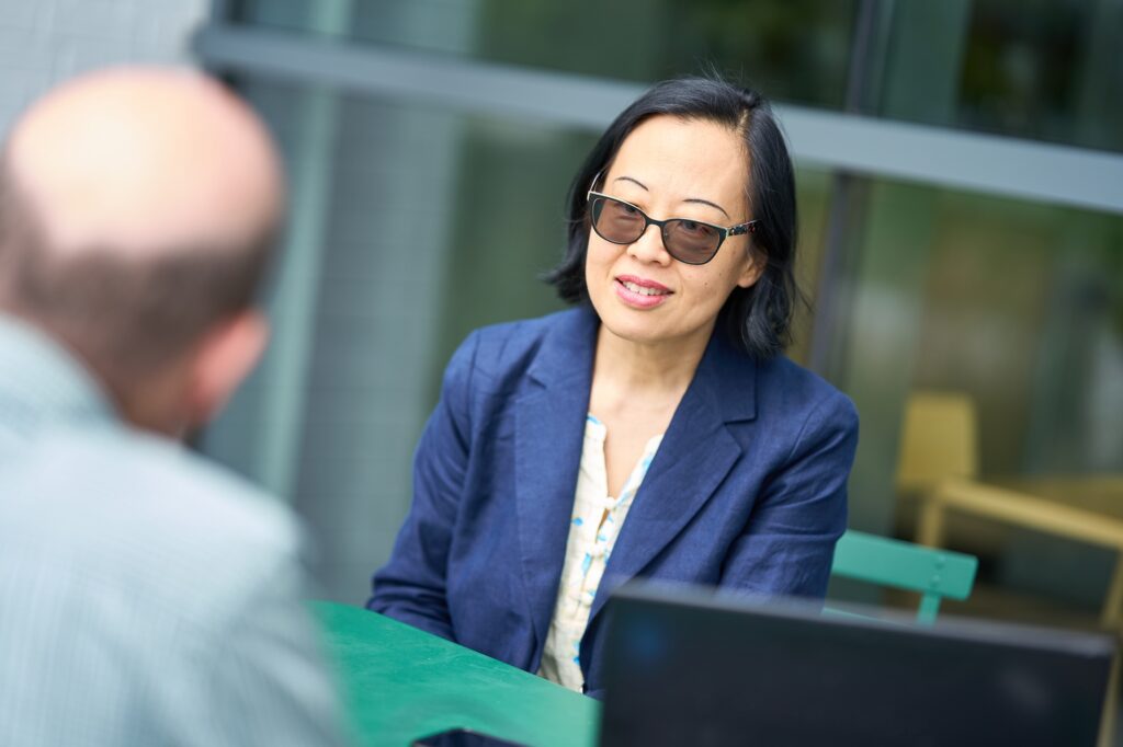 Candid moment of Shiyi Pickrell engaging in conversation on campus. As a Foster MBA alum and former neuroscientist, her journey reflects the power of career reinvention through business education.