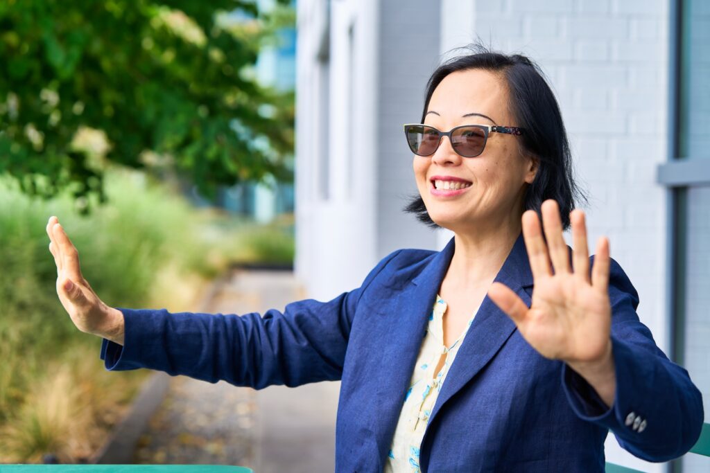 Professional portrait of Shiyi Pickrell in an open office space. As SVP of Data and AI of Expedia Group, she oversees a global engineering team and is building next-generation travel experiences through intelligent technology.